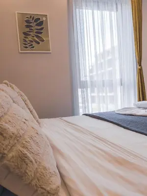 a bed in a bedroom with a large window at Milmari Premier - Daisy Apartments in Kopaonik