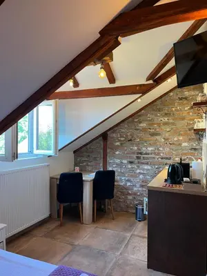 an attic room with a table and two chairs at Apartments PKT DeLux in Niš