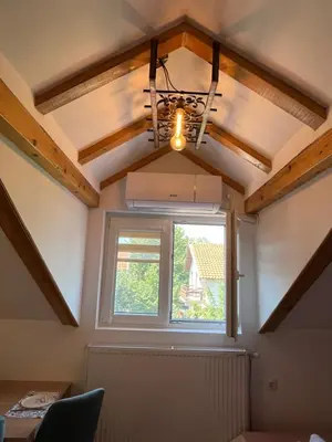 a room with a window and a ceiling with a chandelier at Apartments PKT DeLux in Niš