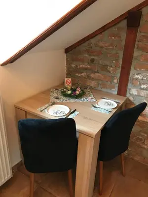 a wooden table with two chairs and plates on it at Apartments PKT DeLux in Niš