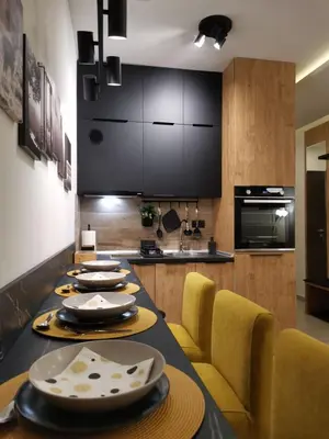 a kitchen with a long table with yellow chairs at Talija Milmari Nlux in Kopaonik