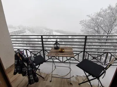 a table and chairs on a balcony with a view at Talija Milmari Nlux in Kopaonik
