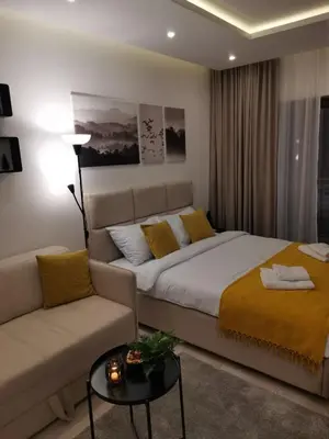 a bedroom with a large bed and a couch at Talija Milmari Nlux in Kopaonik