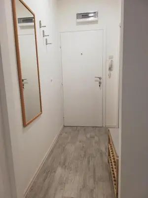a hallway with a door and a mirror at Quince in Bor
