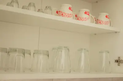 a row of glasses on shelves in a kitchen at Quince in Bor