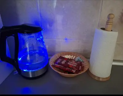 a counter top with a coffee pot and a basket of candy at Victory apartment in Niš