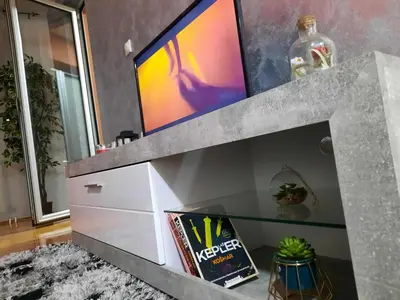 a living room with a tv on top of a entertainment center at Victory apartment in Niš