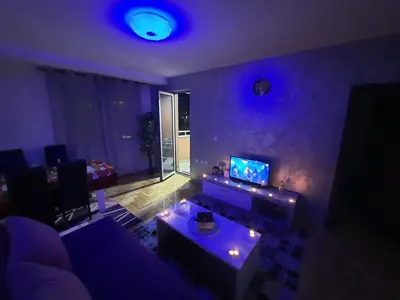 a living room with a purple room with a couch at Victory apartment in Niš