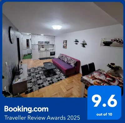 a living room with a purple couch and a table at Victory apartment in Niš