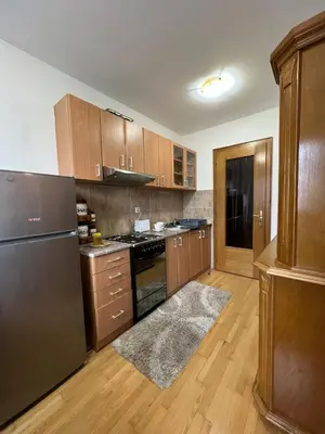 a kitchen with wooden cabinets and stainless steel appliances at Apartman Danica in Vrnjačka Banja