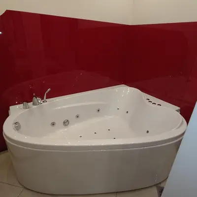 a white bath tub in a bathroom with red walls at Queen 2 in Niš