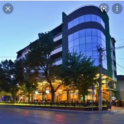 a large glass building with a tree in front of it at Queen 2 in Niš