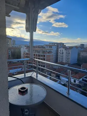 a balcony with a table and a view of a city at Queen 2 in Niš