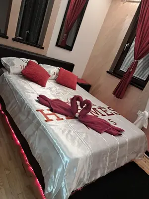a bed with red pillows and a sign that reads hotel at Queen 2 in Niš