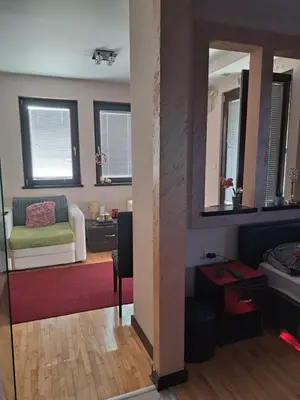 a living room with a couch and a mirror at Queen 2 in Niš