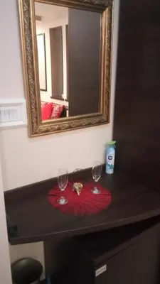 two wine glasses sitting on a table in front of a mirror at Queen 2 in Niš