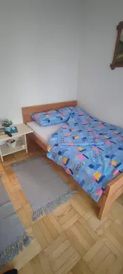 a bedroom with a bed with a comforter on it at Marina in Vrnjačka Banja