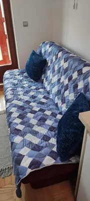 a blue and white couch with pillows on it at Marina in Vrnjačka Banja