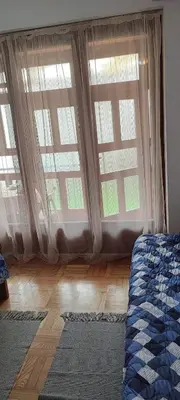 a bedroom with two large windows and a bed at Marina in Vrnjačka Banja