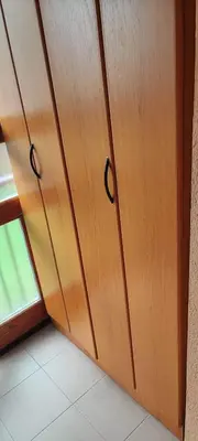 a wooden cabinet with black handles next to a window at Marina in Vrnjačka Banja