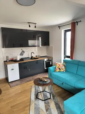 a living room with a blue couch and a table at Apartman Nađa in Soko Banja