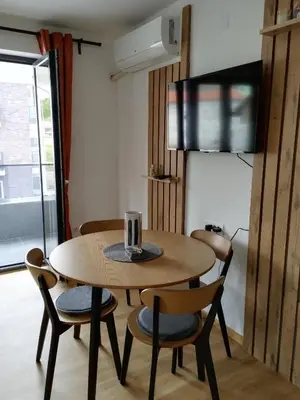 a wooden table and chairs in a room at Apartman Nađa in Soko Banja