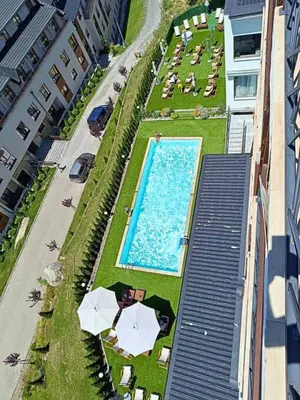 an overhead view of a swimming pool with umbrellas at Golden view apartment P82 - Milmari Apartments & SPA in Kopaonik