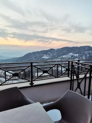 a balcony with two chairs and a view of the mountains at Golden view apartment P82 - Milmari Apartments & SPA in Kopaonik