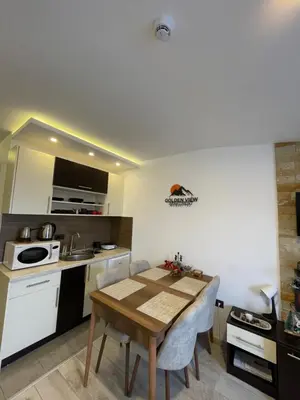 a kitchen with a wooden table in a room at Golden view apartment P82 - Milmari Apartments & SPA in Kopaonik