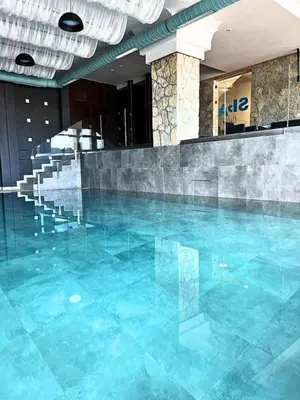 a swimming pool with blue water in a building at Golden view apartment P82 - Milmari Apartments & SPA in Kopaonik