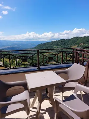 a table and chairs on a balcony with a view at Golden view apartment P82 - Milmari Apartments & SPA in Kopaonik