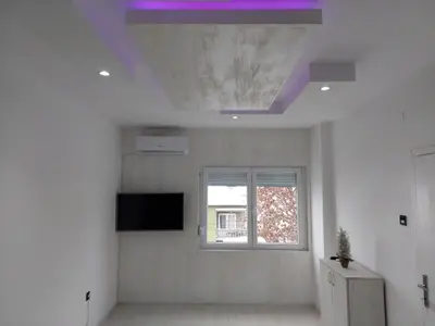 a room with a ceiling with a tv and a window at Apartman Aleksić u centru grada in Knjazevac.