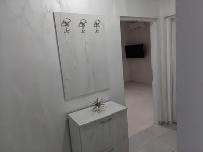 a white bathroom with a mirror and a sink at Apartman Aleksić u centru grada in Knjazevac.