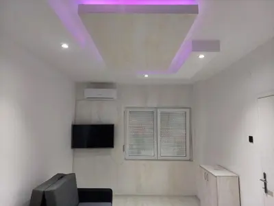 a living room with a ceiling with purple lights at Apartman Aleksić u centru grada in Knjazevac.