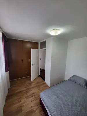 an empty bedroom with a bed and a closet at Apartman Nina in Niš