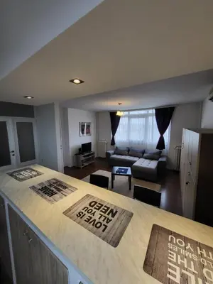 a kitchen and living room with a bar and a couch at Apartman Nina in Niš