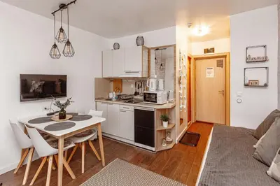a kitchen and a living room with a table at Grand Lux Koznik Center in Kopaonik