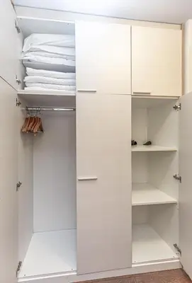 a closet with white cabinets and towels at Grand Lux Koznik Center in Kopaonik