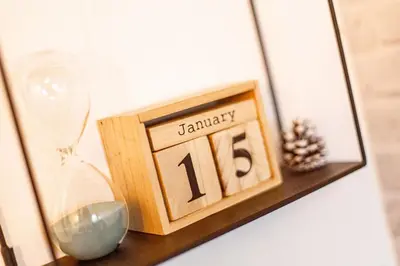 a clock sitting on a shelf next to a glass at Grand Lux Koznik Center in Kopaonik