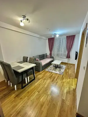 a living room with a couch and a table at Amarilis Apartman in Kopaonik