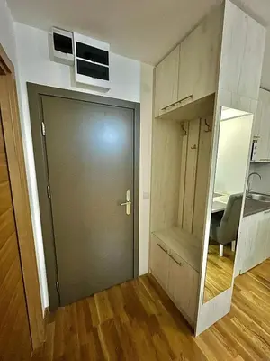 a hallway with a door and a room with a chair at Amarilis Apartman in Kopaonik