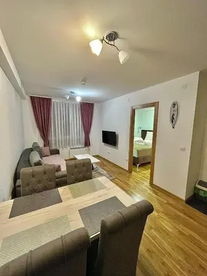 a living room with a couch and a table at Amarilis Apartman in Kopaonik