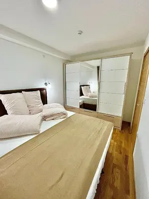 a bedroom with a large bed with a large mirror at Amarilis Apartman in Kopaonik