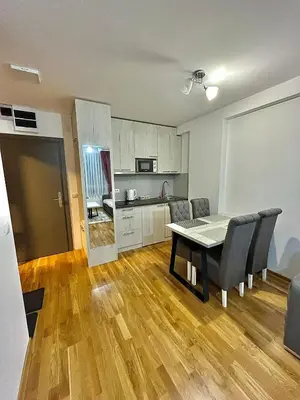 a kitchen and dining room with a table and chairs at Amarilis Apartman in Kopaonik