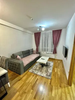 a living room with a couch and a table at Amarilis Apartman in Kopaonik