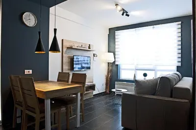 a kitchen and dining room with a table and a couch at Apartman Čardaka 11/42 in Kopaonik