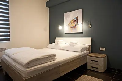 a bed with white sheets and towels on it at Apartman Čardaka 11/42 in Kopaonik