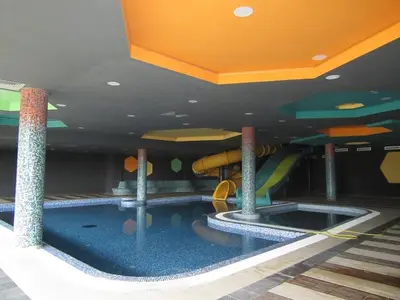 a indoor swimming pool with a slide in a building at Apartman Čardaka 11/42 in Kopaonik