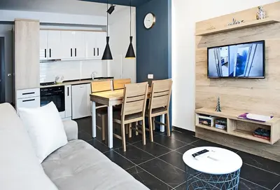 a living room with a couch and a table and a kitchen at Apartman Čardaka 11/42 in Kopaonik