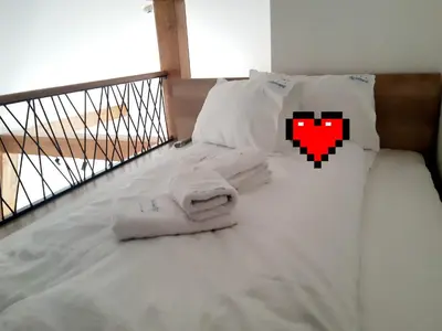 a bed with white sheets and pillows on a balcony at White Eagle Kopaonik - Beli Orao in Kopaonik